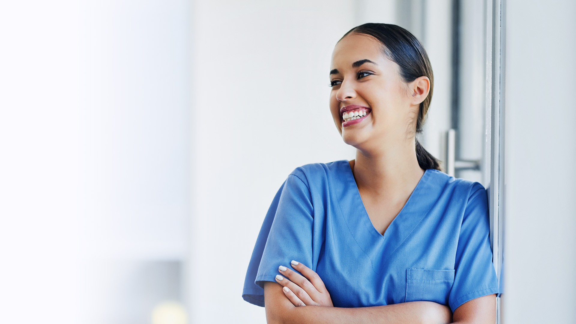 Lächelnde ilomed Pflegekraft mit verschränkten Armen Lächelnde ilomed Pflegekraft mit verschränkten Armen