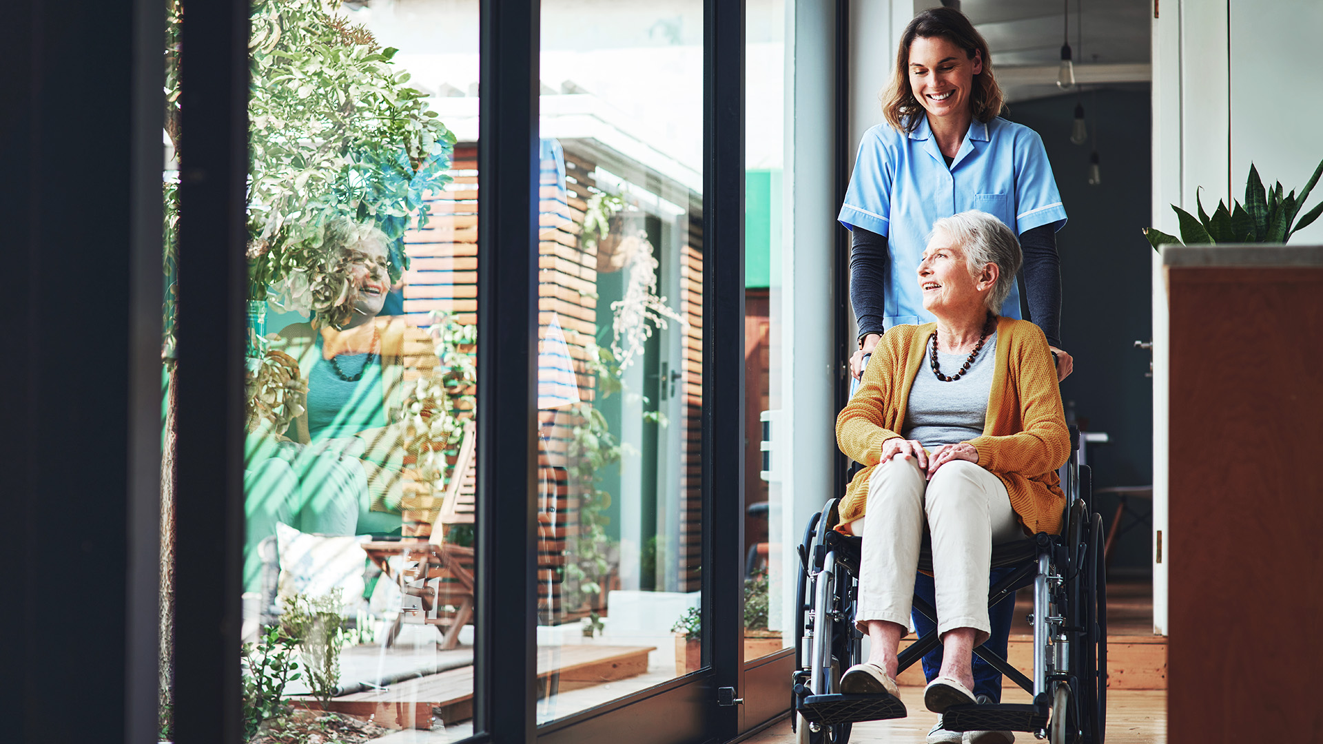 ilomed Pflegekraft schiebt eine ältere Dame im Rollstuhl